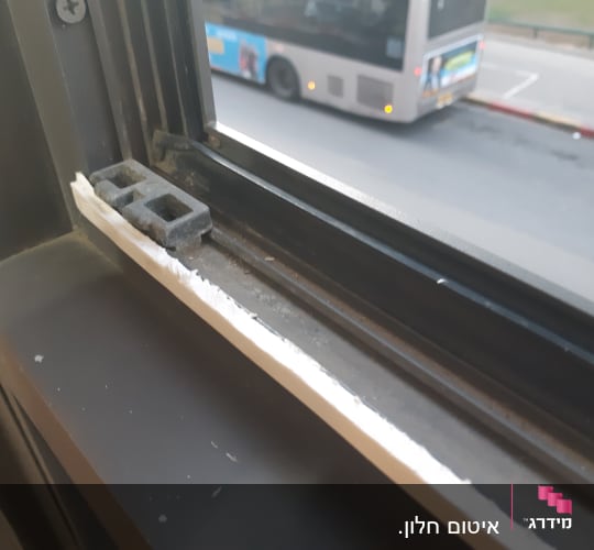 מסגרת חלון עם תריסים פתוחים ומנגנון נעילה